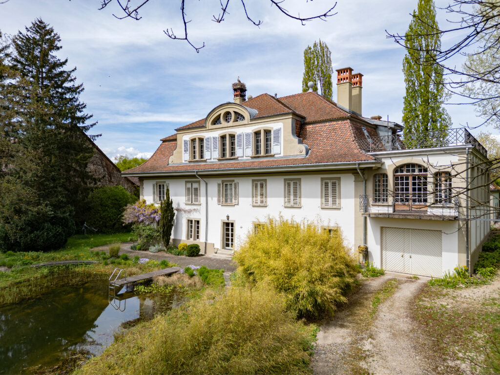 Aufnahme der Südseite eines Herrschaftshauses in Avenches. Links ist der Schwimmteich, rechts die Terrasse über dem grossen Ballsaal mit Balkon zu sehen.