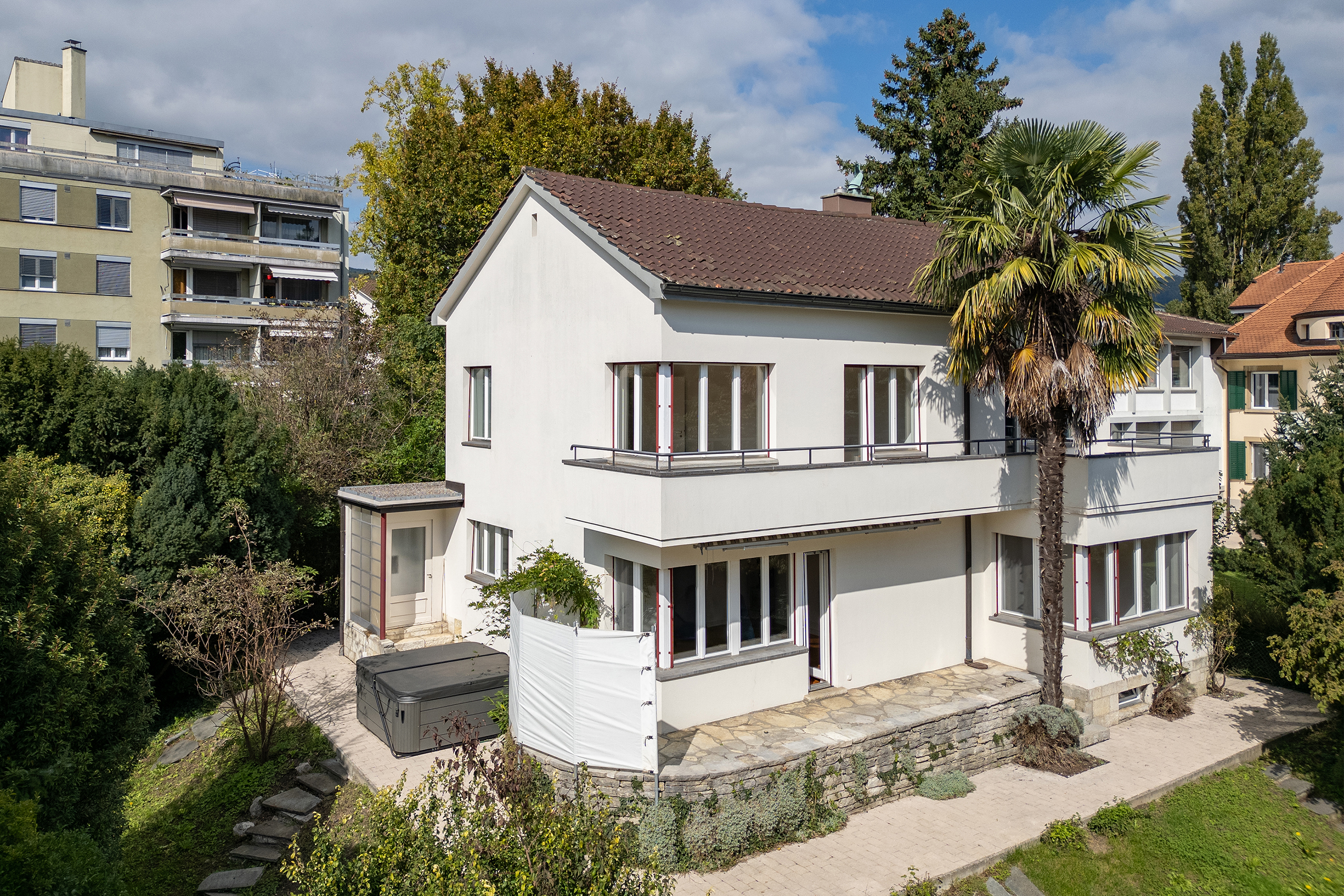 In Biel wird ein grosses Einfamilienhaus mit Garten und einer Palme verkauft.