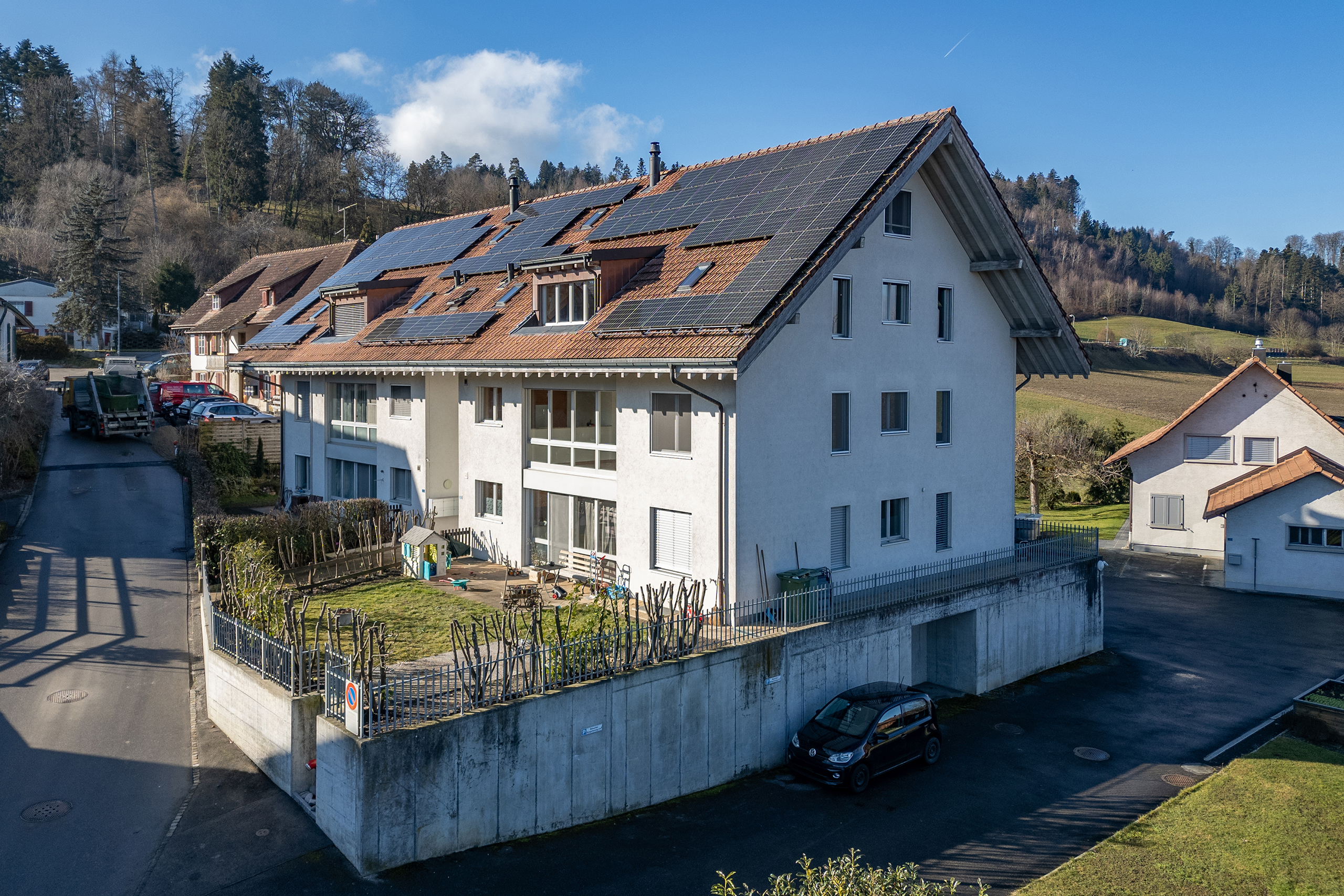 Drohnenansicht auf die Ostseite eines Mehrfamilienhauses in der Gemeinde Schüpfen.