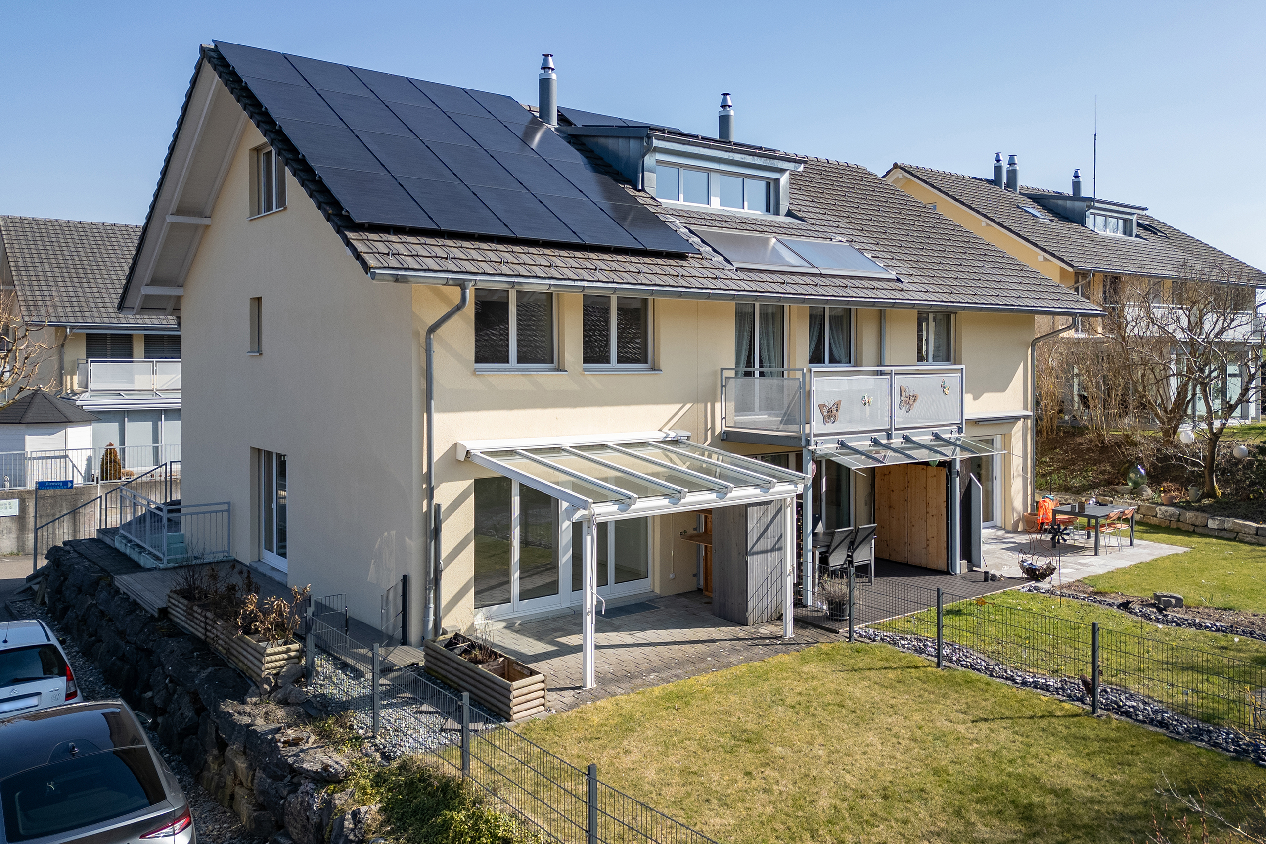 Wir bieten Drohnenfotos für Immobilien an. Hier sehen wir die Aussenansicht eines Eckhauses in Münchenbuchsee. Die neue Photovoltaikanlage kommt gut zur Geltung.