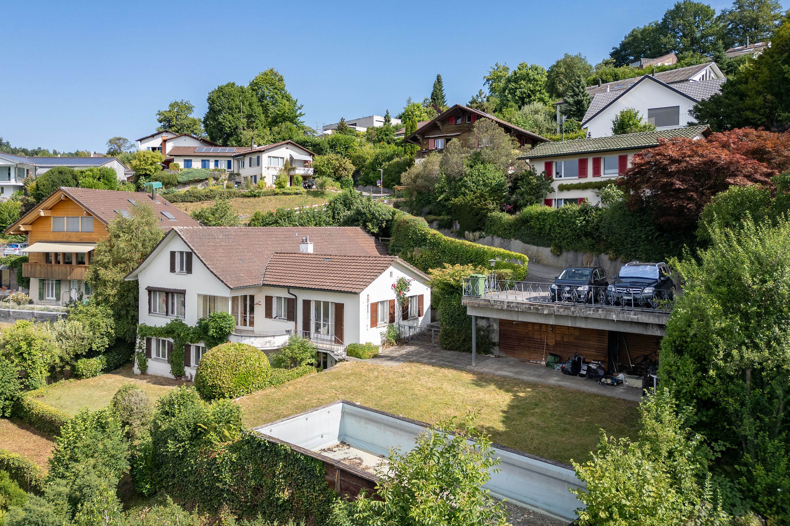 An unverbaubarer Lage in Stettlen. Terrassierter Garten mit Pool und gedecktem Sitzbereich.